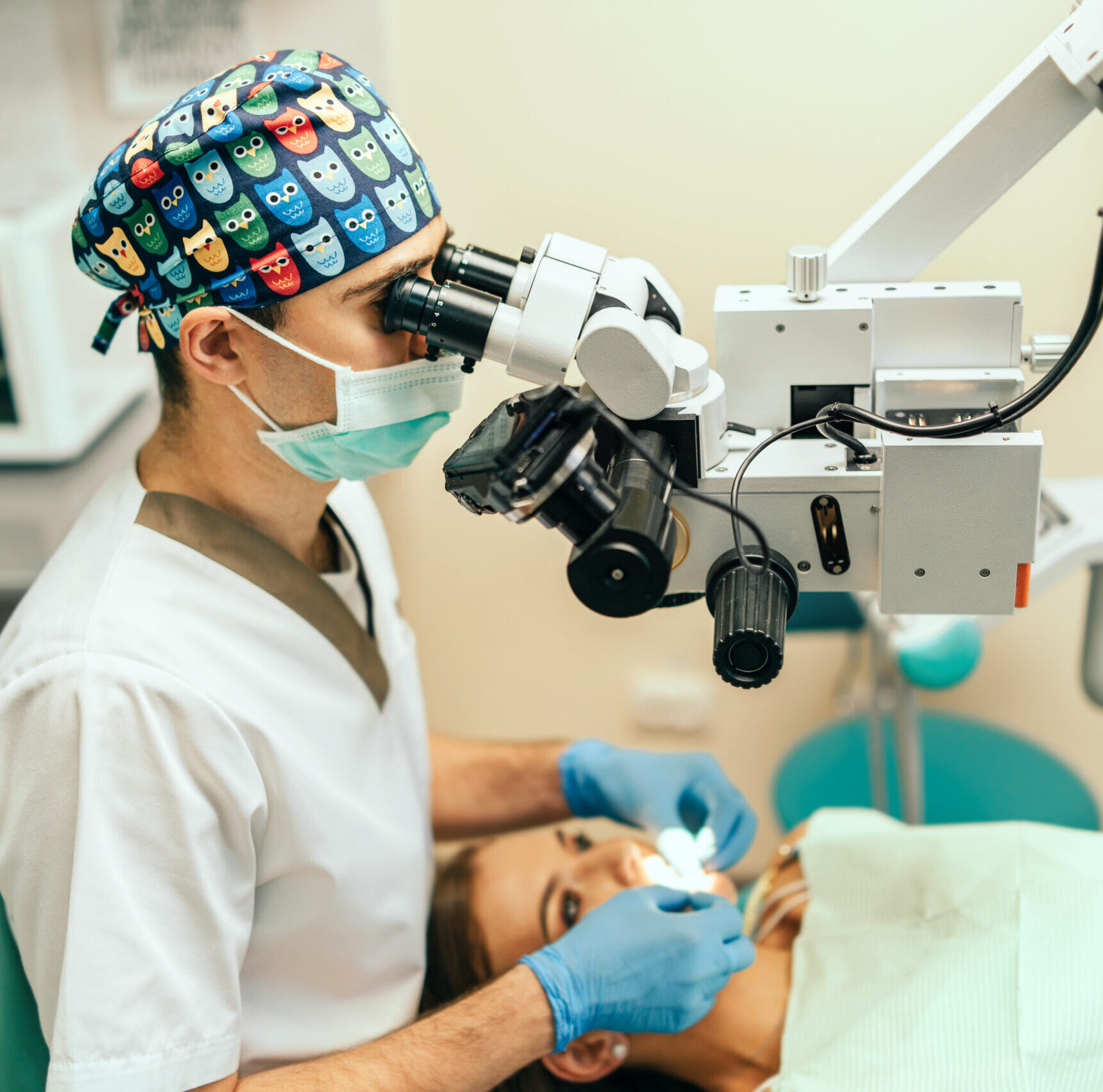 Dentist examine oral cavity of female patient with microscope