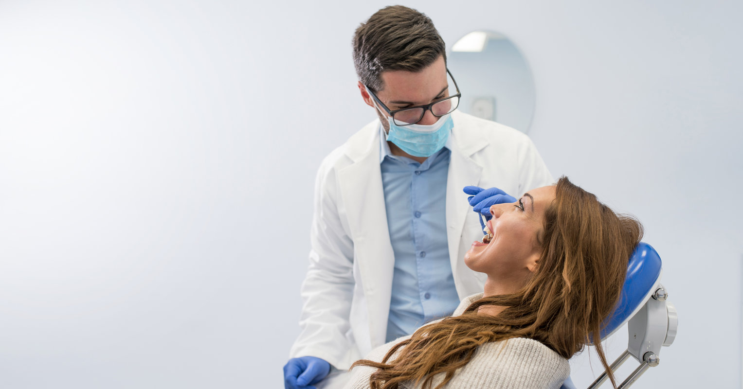 High angle view of dentist examining woman with dental equipments