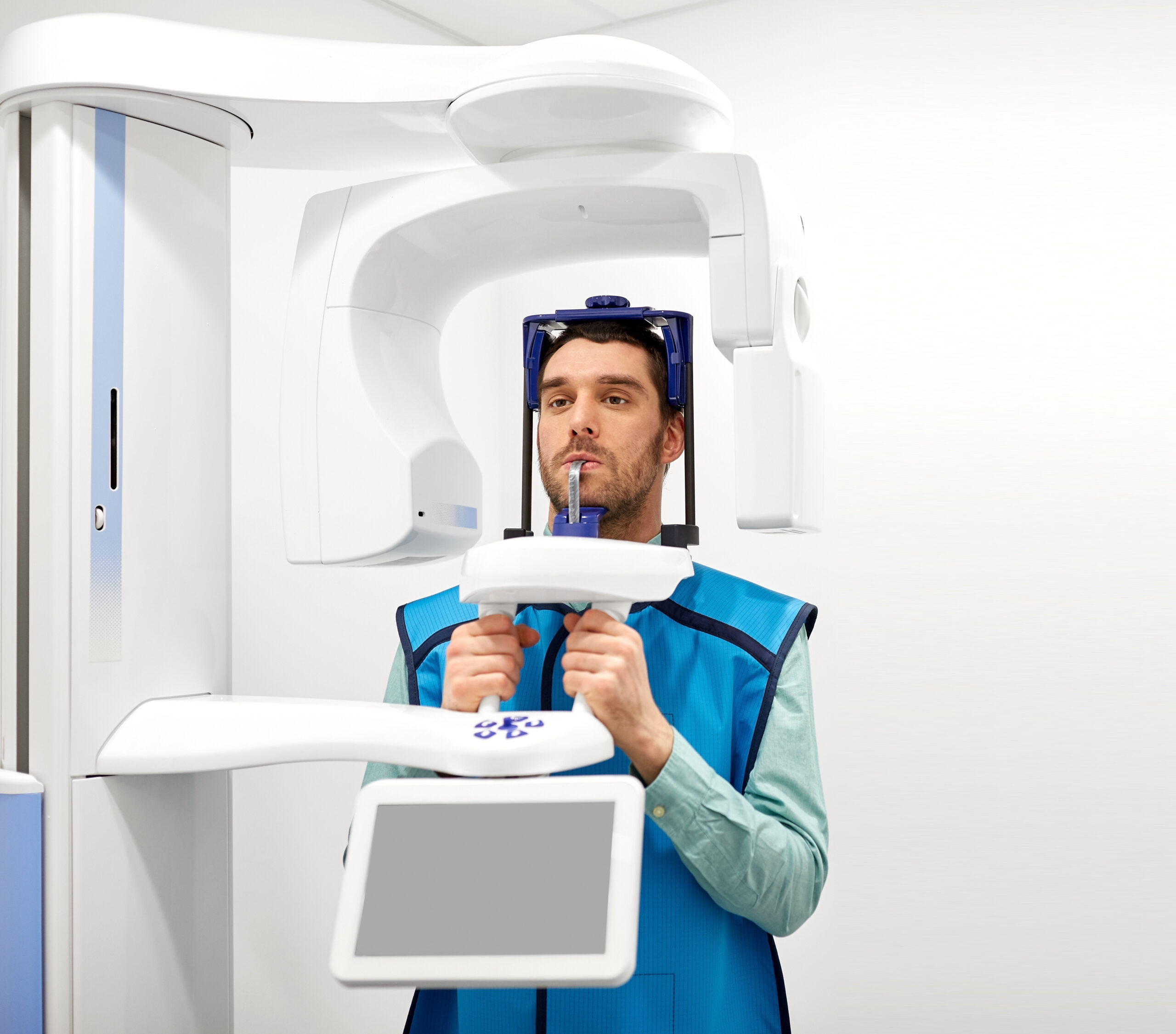 medicine, dentistry and healthcare concept - male patient having panoramic x-ray scanning procedure at dental clinic