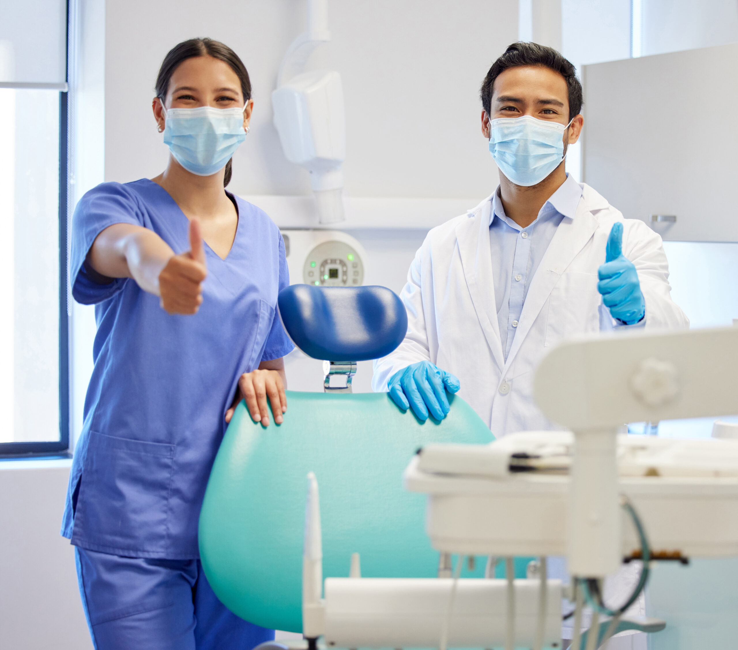 Dentist team, face mask and thumbs up portrait for.medical industry and teamwork. Assistant woman and asian man or healthcare staff together for dental care, oral health and wellness at practice.